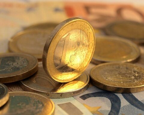 Beamte in NRW zweifeln an rechtskonformer Bezahlung; Euromünzen symbolisieren finanzielle Unsicherheit.