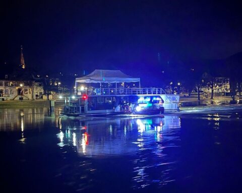 Abgeschlepptes Hausboot auf der Mosel, Feuerwehr im Einsatz, ruhige Wasseroberfläche, keine Personen.
