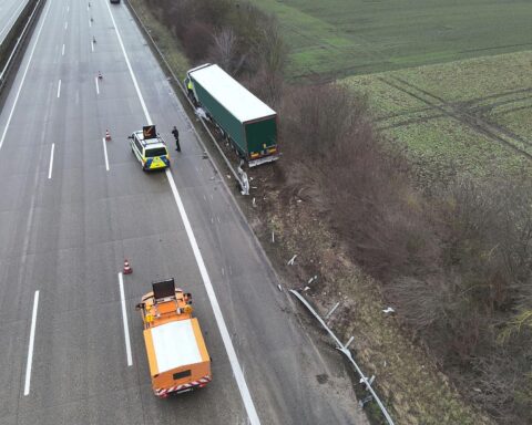 Unfallstelle mit verunfalltem Sattelzug, Trümmern und Feuerwehrmaßnahmen zur Gefahrenminimierung.