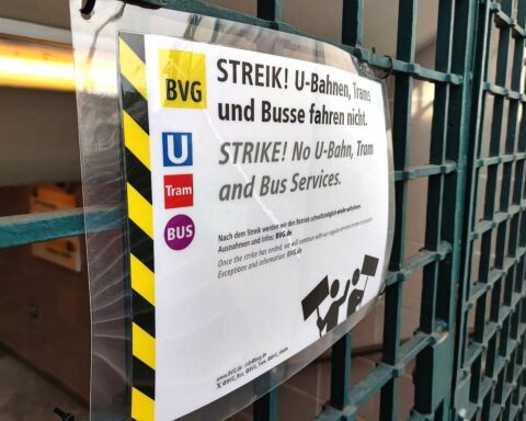 Streikende Verkehrsbetriebe in Berlin, leere Straßenbahn, Protestplakate, symbolisieren öffentliche Unruhe und Herausforderungen.