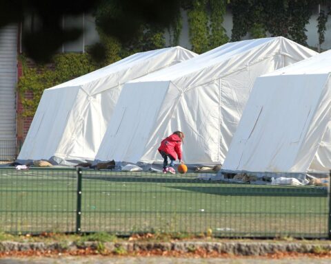 Flüchtlingskind in Zeltstadt, symbolisiert menschliche Notlage und drängende Rückkehrdebatte nach Syrien.