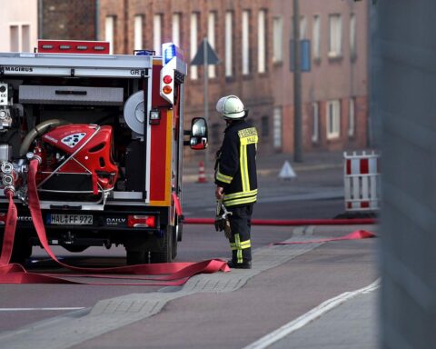 Feuerwehr löscht brennenden Peugeot 5008; Nachtaufnahme mit Flammen und Eis auf der Straße.