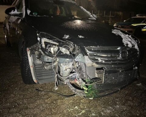 Zwei verunfallte PKW an einer Kreuzung, Polizei und Schadensbewertung im Hintergrund.