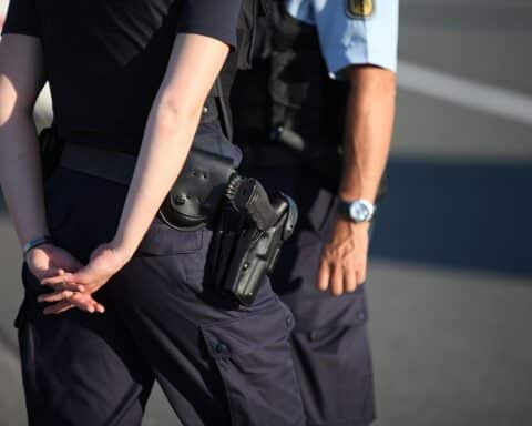 Polizisten am Einsatzort, Rettungswagen, besorgte Senioren, Polizeiabsperrungen in einem Seniorenzentrum.