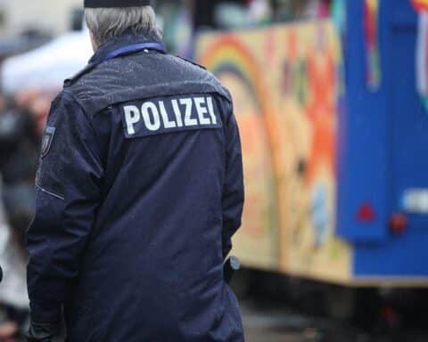 Polizisten in Karnevalsverkleidung überwachen friedliche Feiernde auf dem Schillerplatz in Mainz.