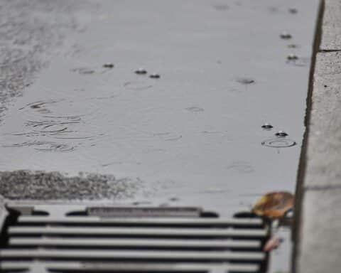 Wolkenverhangenes Wetter mit Regen und milderen Temperaturen in Hessen, Menschen im Regen.