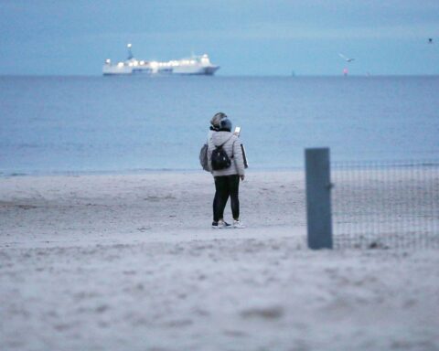 Spaziergänger an der deutschen-polnischen Grenze in winterlicher, kalter Landschaft mit Wolken.