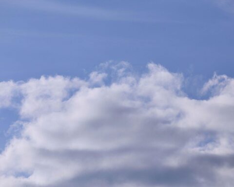 Blauer Himmel mit einigen Wolken, der wechselhaftes, trockenes Wetter symbolisiert.