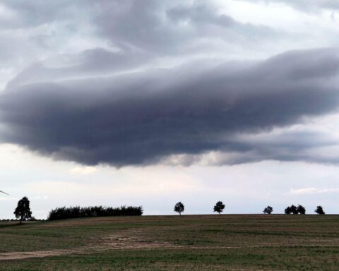 Dunkle Wetterwolken über einem Acker, symbolisieren wechselhaftes und unbeständiges Wetter in Baden-Württemberg.