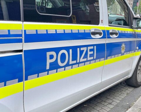 Unfallstelle mit beschädigtem Auto, Einsatz von Polizei und Rettungsdiensten nach Verkehrsunfall.