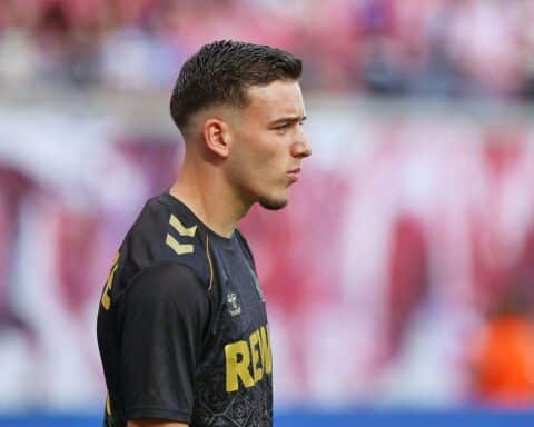 Zwei Fußballspieler in action während eines spannenden Spiels, mit jubelnden Fans im Hintergrund.