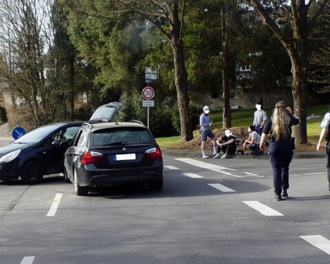 Unfallstelle mit beschädigten Fahrzeugen, Polizei im Einsatz, Rettungswagen und Straßenabsperrung.