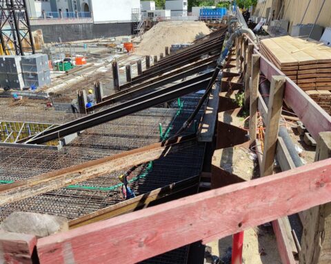 Eine Baustelle mit Baufahrzeugen und Arbeitern, Symbol für sinkenden Auftragseingang im Bauwesen.