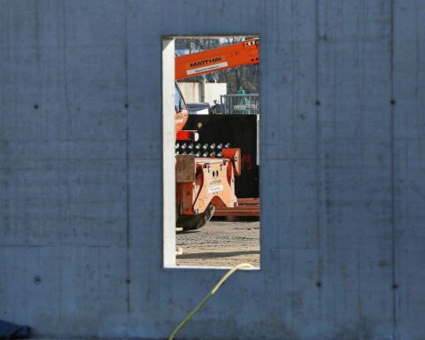 Baustelle mit Handwerkern, Maschinen und Bauarbeiten zur Veranschaulichung des Umsatzwachstums im Ausbaugewerbe.