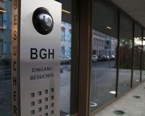 Bundesgerichtshof-Logo mit Symbolen für Rechtsprechung und Gerechtigkeit, Hintergrund: Justizgebäude.