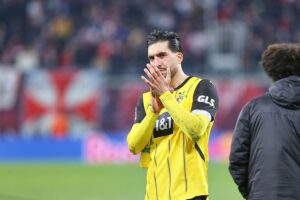 Emre Can in Dortmund-Trikot, lächelnd, symbolisiert Vertragsverlängerung und Comeback nach Verletzung.