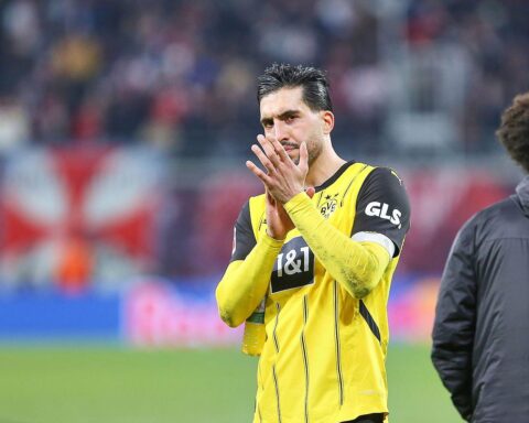 Emre Can in Dortmund-Trikot, lächelnd, symbolisiert Vertragsverlängerung und Comeback nach Verletzung.