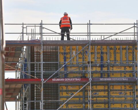 Bauarbeiter auf Baustelle zeigen steigende Bauproduktion im Tiefbau, gesunken im Hochbau.