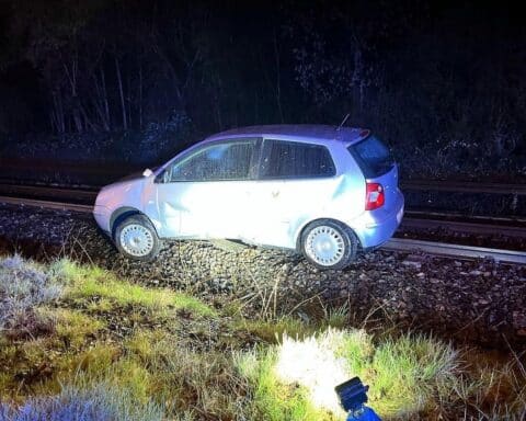 Unfallauto auf Bahngleisen, schwer verletzte Beifahrerin, Polizei vor Ort, Nachtaufnahme.
