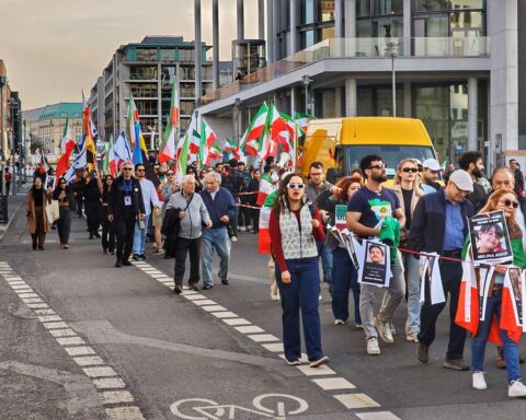 Demonstration für Regimewechsel im Iran mit Menschenmengen und Protestplakaten.
