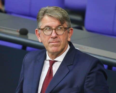 Wolfram Weimer in einem kritischen Moment, umgeben von Büchern und kulturellen Symbolen.