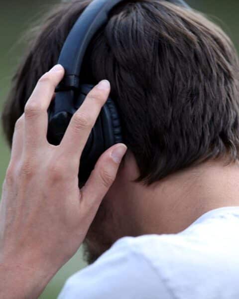 Mann mit Kopfhörern feiert BTS' Nummer-eins-Erfolg in den deutschen Album-Charts.