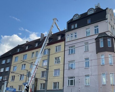 Feuerwehr löscht Brand in Restaurantabsauganlage; Rauchentwicklung sichtbar, kein Personenschaden.