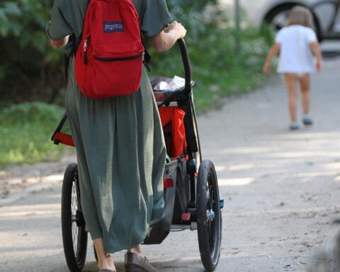 Familie mit Kind und Kinderwagen, symbolisiert Unterstützung und Entlastung durch antragsloses Kindergeld.