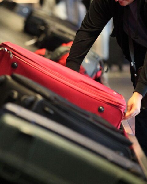 Deutsche Reisende am Gepäckband, im Hintergrund Sorgen um Rückreise aus Krisengebiet.