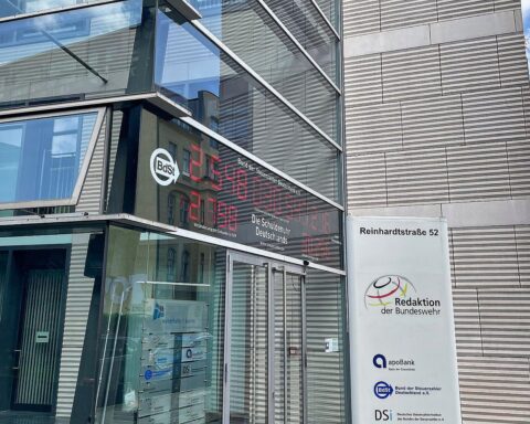 Eine Schuldenuhr, die die Schuldenentwicklung visualisiert, vor einem Berliner Gebäudekomplex.