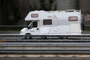 Ein Wohnmobil fährt auf einer Autobahn, symbolisiert den wachsenden Campingboom in Deutschland.