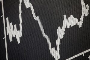 Anzeigetafel der Frankfurter Börse mit Dax-Fall und steigenden Rohölpreisen. Einfluss auf Märkte.