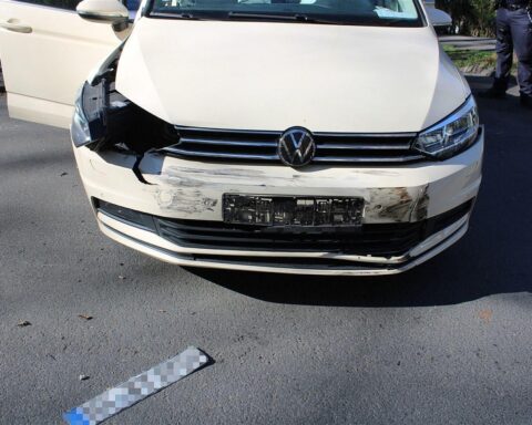 Verkehrsunfall mit drei Verletzten, zwei beschädigte Fahrzeuge und Polizeipräsenz an Unfallstelle.