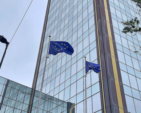 EU-Fahnen vor Brüsseler Hintergrund, symbolisieren diplomatische Bemühungen um humanitäre Hilfe.