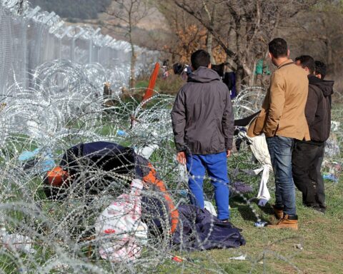 Flüchtlinge vor einem Grenzzaun symbolisieren die Herausforderungen der Migration in Europa.