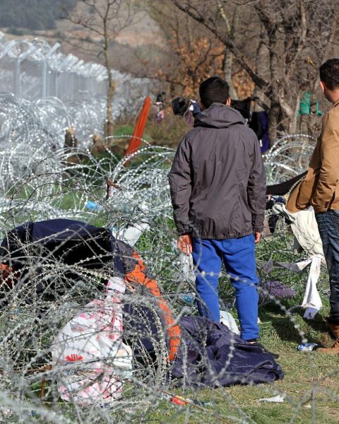 Flüchtlinge vor einem Grenzzaun symbolisieren die Herausforderungen der Migration in Europa.
