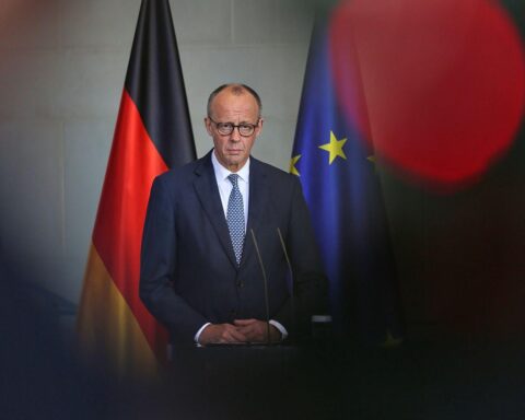 Friedrich Merz diskutiert Verantwortung im EU-Parlament, Umgeben von politischen Symbolen und Debatten.