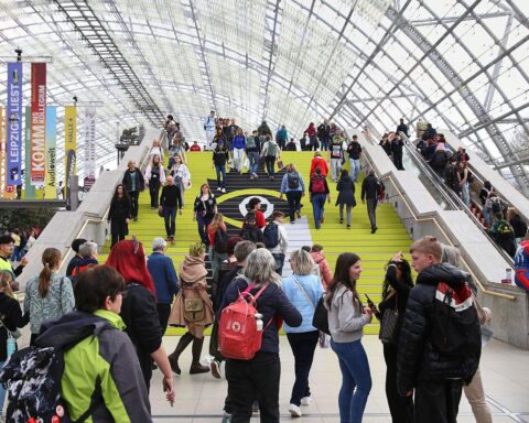 Menschenmengen von Lesern und Ausstellern, lebendige Buchmesse mit zahlreichen Veranstaltungen und Diskussionen.