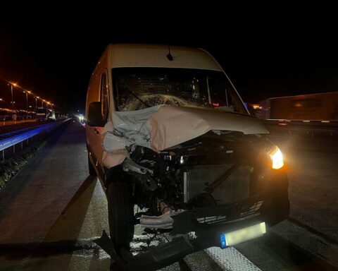Kollisionsszene zwischen Kleintransporter und Sattelzug auf Autobahn, Nachtaufnahme mit Blaulicht.