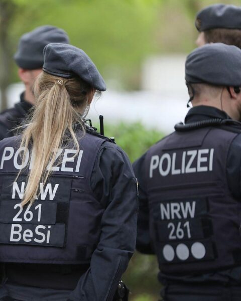 Polizisten an der Unfallstelle, abgesperrte Bundesstraße, beschädigter Alfa Romeo, Baumunfall.