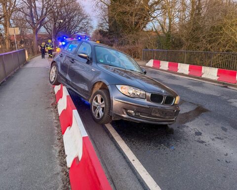 Eine kaputte Leitwand an einer Brücke, Feuerwehrmann bei der Bergung eines Pkw.