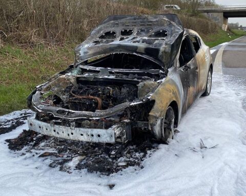 Ein ausgebrannter PKW auf der Autobahn, Feuerwehr im Einsatz, erhebliche Verkehrsbehinderungen.