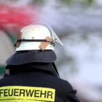 Feuerwehrmann im Einsatz, Brandmelder ausgelöst, keine Schäden festgestellt, ruhige Rückkehr.