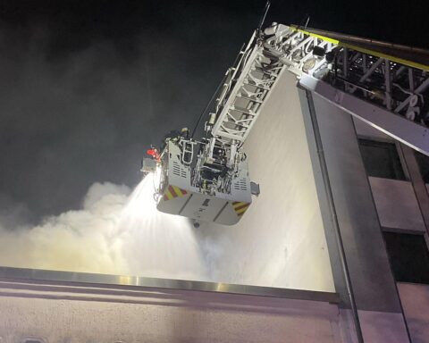 Feuerwehr löscht Brand mit Drehleiter in Dortmunds Innenstadt, liess Flammen am Dach sichtbar.