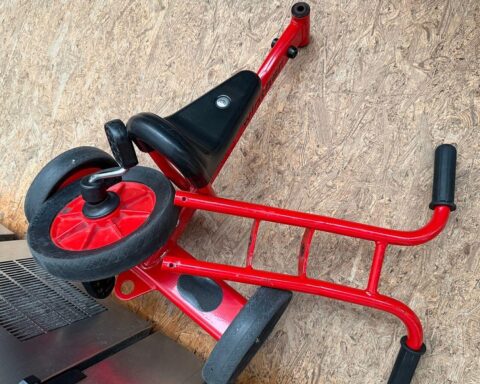 Feuerwehr befreit Kind vorsichtig aus eingeklemmtem Dreirad in Spielarena.