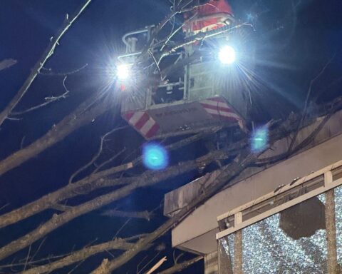 Feuerwehr und THW entfernen umgestürzten Baum von Wohn- und Geschäftsgebäude nachts in Hattingen.