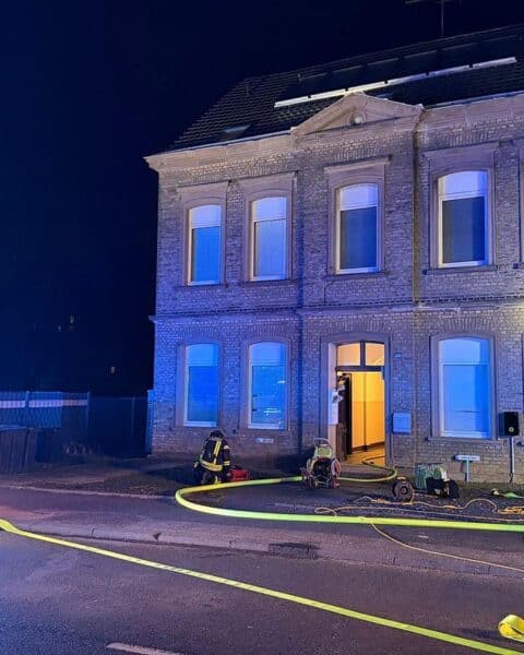 Einsatzkräfte löschen Rauch in Wohnheim, evakuieren hilfebedürftige Bewohner, alle unverletzt.