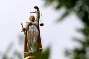 Symbol von Justicia, das Recht und Gerechtigkeit darstellt, sowie digitale Kommunikationselemente.