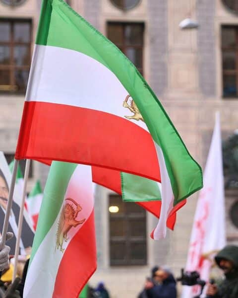 Protestierende Menschen auf der Straße, plakatieren gegen den US-Militäreinsatz im Iran.