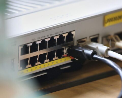 Graues Rechenzentrum mit vielen Servern, Kabeln und Datennetzwerken in modernem Gewerbegebiet.